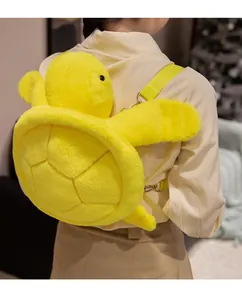 Rear view of a cute yellow plush turtle backpack worn by a model in a cozy setting
