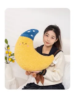 Asian model holding a cute yellow crescent moon plush pillow with a blue sleep cap.