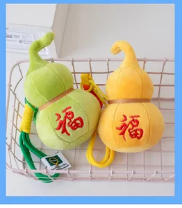 Close-up of green and yellow plush gourd charms with red embroidered Fu characters