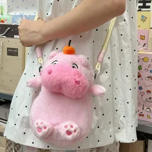Close-up of a cute pink plush hippo crossbody bag featuring heart paw embroidery details