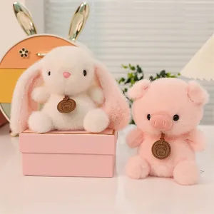 Süße Plüschtiere mit einem weißen Hasen und einem rosa Schwein in einer Geschenkbox