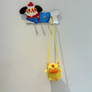 Detailed view of a cute yellow plush Capybara crossbody bag hanging on a decorative hook
