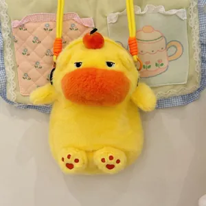 Close-up of cute yellow plush duck bag with sleepy eyes and orange fruit topper