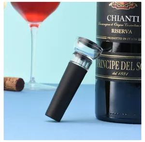 Detail view of a black silicone vacuum wine stopper leaning against a red wine bottle.