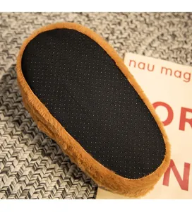 Macro view of non-slip sole with black dotted grip on brown plush capybara slippers