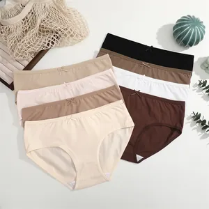 Detailopname van katoenen slips in Maillard aardetinten met verfijnde strikjesaccenten