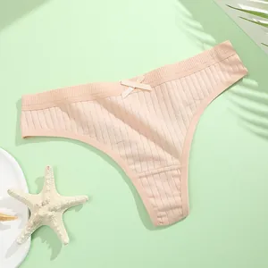 Detailed macro view showing the ribbed cotton texture and delicate bow on a peach thong