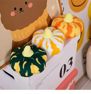 Detailansicht von drei farbenfrohen Plüschkürbis-Kissen für Halloween-Heimdekoration