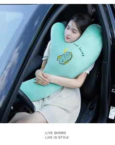 Modelo durmiendo en coche con almohada cervical de felpa con dinosaurio verde menta.