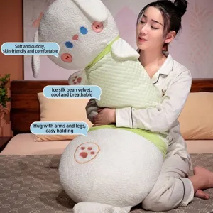 Long cartoon cat plush body pillow in white and green, held by a woman on a bed.