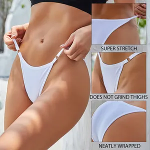 Detailaanzicht van witte katoenen bikini met lage taille, dunne bandjes en ringen