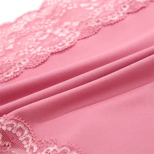 Close-up detail of soft pink seamless fabric with delicate lace trim edging