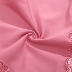 Close-up of pink seamless fabric showing texture and lace trim for women's panties.