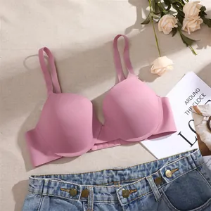 Vista de detalle de un sujetador push-up rosa sin costuras con aros sobre fondo plano