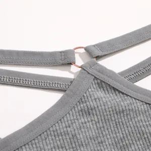 Close-up van grijze geribbelde stof en metalen ring van de string met dubbele tailleband.