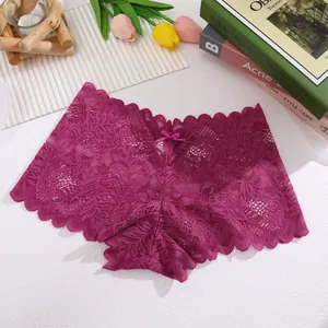 Elegant translucent lace panties in dark magenta color laid flat with tulip flowers