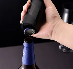 Close-up van een zwarte magnetische automatische bieropener die een kroonkurk verwijdert.
