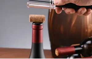 Nahaufnahme eines Luftdruck-Weinöffners, der einen Korken aus der Flasche hebt.