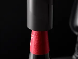 Detailopname van een slanke zwarte automatische bieropener op de hals van een fles