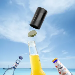 Zwarte automatische magnetische bieropener zwevend boven een fles op het strand