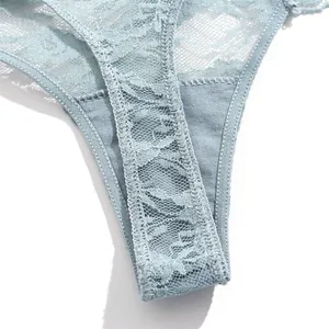 Close-up detail of women's light blue lace thong underwear showing floral translucent pattern.