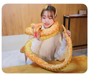 Close-up detail of a long orange patterned plush snake python toy held by a model