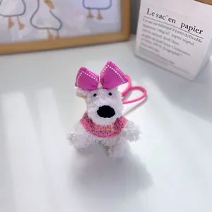 Detailed macro view of white plush West Highland dog pendant with pink bow accessory