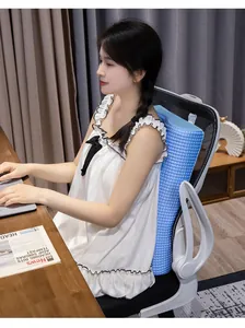 Female professional using a blue waffle-textured lumbar support pillow in an office chair.