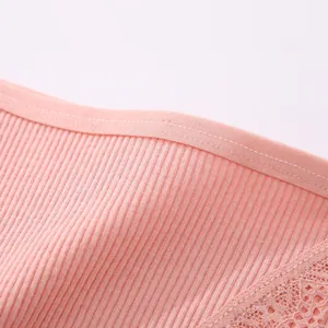 Detailed view of soft pink ribbed cotton fabric and delicate lace on women's underwear.