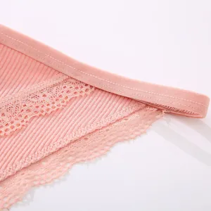 Detailed macro view of pink ribbed fabric and delicate lace trim on low waist women's panties