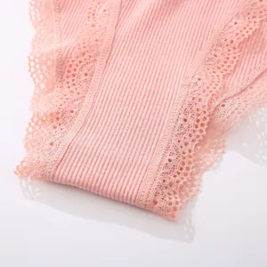 Macro detail view of pink ribbed cotton panties featuring elegant lace embroidery trim.