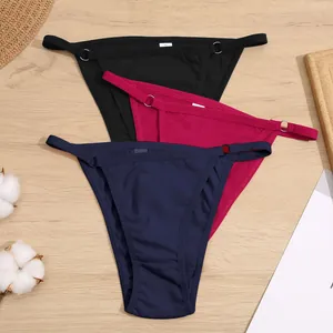 Detail van katoenen bikini-slips met lage taille en metalen ringen in drie kleuren.
