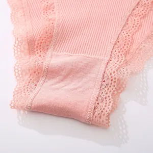 Close-up detail of delicate lace trim and soft ribbed fabric on pink women's panties.