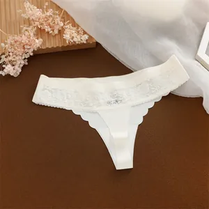 Detail van witte ijssijden string met gebloemde kant en een elegant naadloos ontwerp