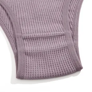 Dettaglio macro della trama di cotone a nido d'ape color malva su perizoma donna