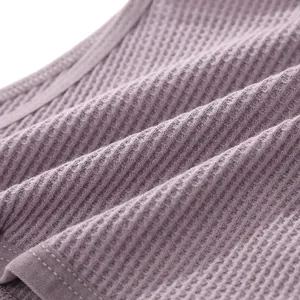 Primo piano del tessuto in cotone a nido d'ape lavanda con cuciture fini per intimo donna.