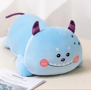 Close-up of a cute blue monster plush bolster pillow with purple horns and tail