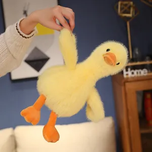 Detailed view of a soft yellow plush duck toy made of golden mink velvet being held.
