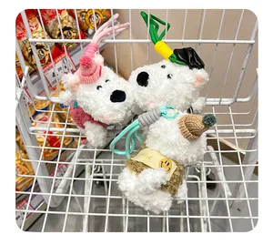 Detailed close-up of cute Westie plush dog keychains with knitted hats in a wire basket.