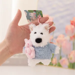 Dettaglio del portachiavi in peluche Westie con maglione blu e coniglietto rosa
