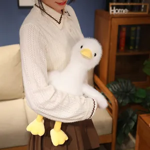 Cute white plush duck toy doll with macaron yellow beak and feet held by a person.