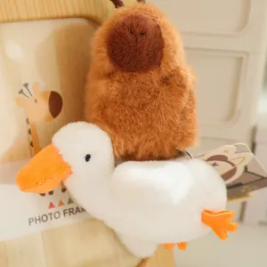Schattige bruine pluche capibara op een witte eend trekkoord speelgoed sleutelhanger