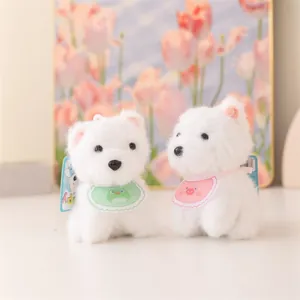 Primo piano di due teneri portachiavi a cucciolo di peluche bianco con bavaglini.