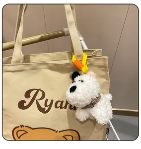 Close-up of fluffy West Highland White Terrier dog plush keychain hanging on a bag