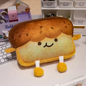 Primer plano de un lindo cojín de peluche con forma de tostada y cara sonriente en mesa.
