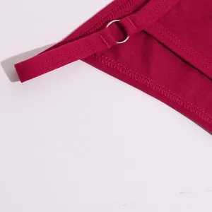Detailopname van een donkerroze katoenen bikinibroekje met een zilveren metalen ring