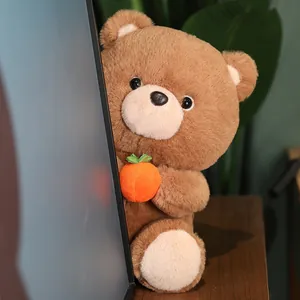 Detailed view of brown teddy bear plush toy holding a cute orange persimmon fruit