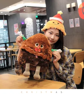 Asian model wearing a yellow plush Christmas tree hat holding a gingerbread man toy.