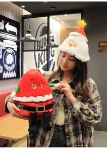 Detail of an Asian woman wearing a glowing white Santa hat and holding a red Christmas plush toy