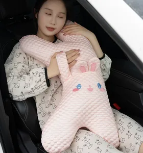 Niña asiática usando una almohada de felpa de conejo rosa para dormir en el coche.